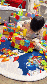 a child is playing with a bunch of colorful toys on a rug .