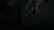 a close up of a person holding a gun with the sun shining through it