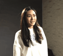 a woman wearing a white sweater that says ' ar ' on it