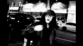 a black and white photo of a person in a hooded jacket in front of a store that says o'reilly