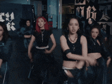 a group of women are dancing in a dark room and one of them is wearing a black tank top