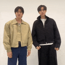 two young men standing next to each other wearing different jackets
