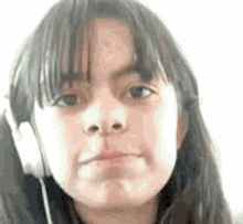 a young girl wearing headphones is making a face .