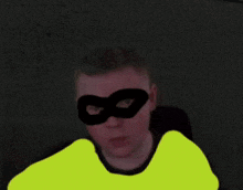 a man wearing a yellow shirt and a black mask with the number 8 on it
