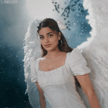 a woman in a white dress with angel wings has the year 2005 on the bottom of the image