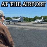 a man looking at a plane with the words at the airport written above it