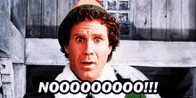 a man in a christmas elf costume is making a funny face and saying nooooooo !!!