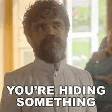 a man with a beard and curly hair says you 're hiding something