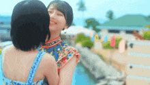 two young women are hugging each other and smiling