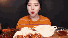 a woman is sitting at a table with plates of food on it .