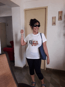 a woman wearing sunglasses and a white shirt with the usa on it