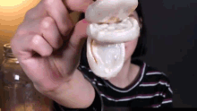 a woman is holding a condom in her hand in front of her face .