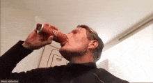 a man drinking from a red can with the name mads on the bottom right