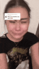 a woman is crying with a speech bubble that says shut ya sensitive ass up lol on her forehead .