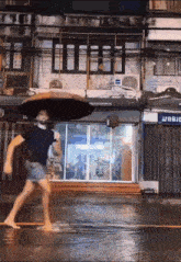 a man is walking in the rain with an umbrella in front of a store that says ' jc ' on it