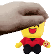a hand is holding a stuffed toy that looks like a lego man holding a pizza .