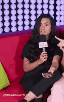 a woman sitting on a couch with a microphone that says multi show on it