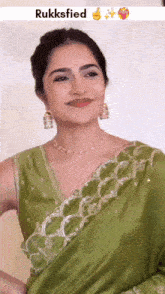 a woman wearing a green saree and a necklace with the word rukksfied on the bottom