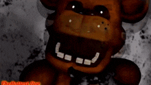 a close up of a brown teddy bear with white teeth and black eyes .