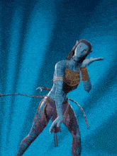 a woman in a blue avatar costume is dancing