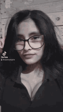 a woman wearing glasses and a black shirt has a tiktok icon on her face