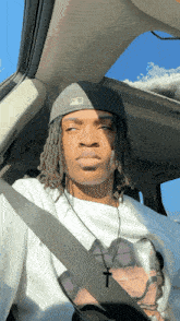 a young man wearing a hat that says ny on it is sitting in a car