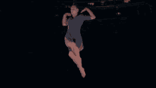 a woman in a blue dress is dancing on a stage