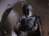 boba fett from star wars is holding a gun in his hand