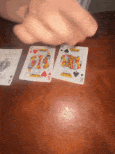 playing cards on a table including a king and queen spades