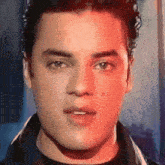 a close up of a young man 's face with a red background