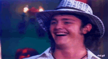 a man wearing a cowboy hat is smiling and laughing .