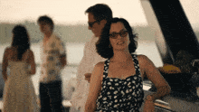 a woman wearing glasses and a black and white polka dot dress