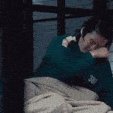 a person wearing a green sweatshirt with the number 3 on it