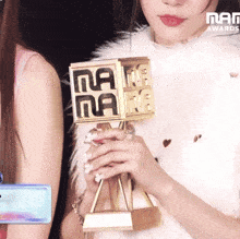 a woman is holding a trophy that has the word nana on it