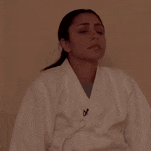 a woman wearing a white karate uniform has a microphone on her collar