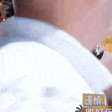 a close up of a person 's back with chinese writing on a yellow sign