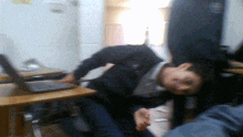 a blurry picture of a man laying on a desk with a laptop