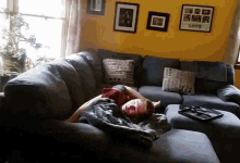 a person laying on a couch in front of a yellow wall with a picture that says love