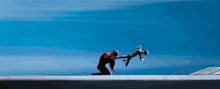 a man is kneeling down to rescue a child from a cliff