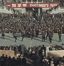 a large crowd of people are gathered under a banner that says " счастливого путь "