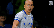 a soccer player wearing a gray and blue cata jersey