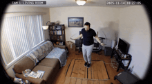a man is jumping a jump rope in a living room with a date stamp of 2025-11-14
