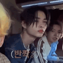a group of young men are sitting in a car and one of them has a piercing in his lip .