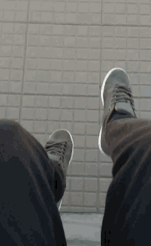 a person 's feet are shown in a close up with a brick wall in the background