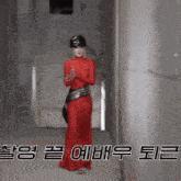 a woman in a red dress and black helmet is standing in a hallway with chinese writing