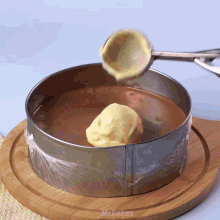 a scoop of ice cream is being poured into a cake pan with mr.cakes written on the bottom