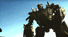 a statue of a robot with a blue sky behind him