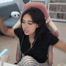 a woman is sitting in a chair with her arms outstretched and a pink back