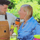 a woman screams into a microphone while talking to a man with a microphone on his head