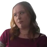 a woman wearing a purple shirt and a gold necklace